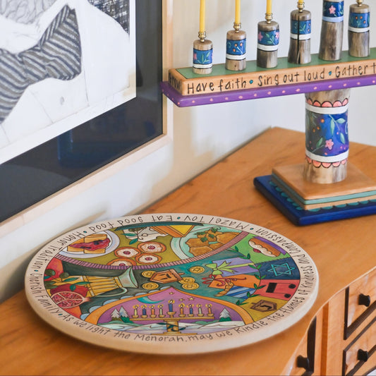 Hanukkah theme lazy susan on a sideboard with a menorah