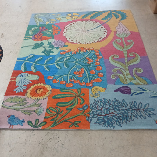 Colorful floral and nature-themed fabric on a concrete floor